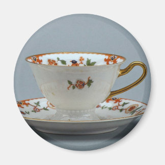 Cup und Untertasse mit bunten Blume darauf. Magnet