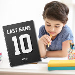 Custom Black Nachname Sports Jersey Nummer Notizblock<br><div class="desc">Name,  Nummer und Schlagschatten sind individuell einstellbar,  sodass Sie ein sportlich aussehendes und dennoch nützliches Notebook einzigartig machen können,  das Ihren Lieblingssport-Teamfarben oder der Zimmerdekoration entspricht. Schwarzer Hintergrund.</div>