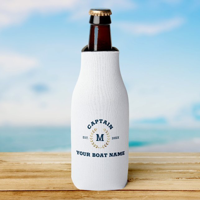Custom Boat Captain Monogram Gold Laurel Nautical Flaschenkühler (Beer bottle in a white cooler with navy text "Captain Your Boat Name," on wooden surface)