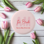 Custom Bride | Pink Monogram Future Mrs. Name Button<br><div class="desc">Fügen Sie jedem Brautfest einen Pop Persönlichkeit hinzu mit diesem Custom Bride Button mit einem weichen rosa monogramm Hintergrund und elegantem Drehbuch, das "The Bride" zusammen mit dem zukünftigen Mrs. Namen ausliest. Dieser niedliche Knopf eignet sich perfekt für Junggeselinnen-Abschiede, Brautpartys oder Hochzeitsfeiern und kann auf Jacken, Wimpern, Geschenktaschen oder Gastgeschenke...</div>