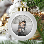 Custom Foto First Christmas Verlobt White Script Keramik Kugel-Ornament<br><div class="desc">Gedenken Sie Ihre Verlobung mit diesem schönen modernen Sakraldekor. Der weiße Text lautet "Unser erstes Weihnachten verlobt", mit dem Wort "verlobt" in eleganter Handschrift mit Schnörkeln vor und nach. Ersetzen Sie das Beispielbild durch Ihr Lieblings-Foto, und fügen Sie Ihre Namen und das Jahr hinzu. Ein Filter mit schwarzem Farbverlauf hilft,...</div>