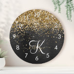 Custom Gold Glitzer Black Sparkgram Monogram Runde Wanduhr<br><div class="desc">Dieses trendige und elegante Round-Clock-Design mit hübschem vergoldeten Glitzer auf schwarz gebürstetem metallischem Hintergrund ist einfach zu personalisieren.</div>