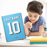 Custom Light Blue Nachname Sports Jersey Nummer Notizblock<br><div class="desc">Name,  Nummer und Schlagschatten sind individuell einstellbar,  sodass Sie ein sportlich aussehendes und dennoch nützliches Notebook einzigartig machen können,  das Ihren Lieblingssport-Teamfarben oder der Zimmerdekoration entspricht. Hellblauer Hintergrund.</div>
