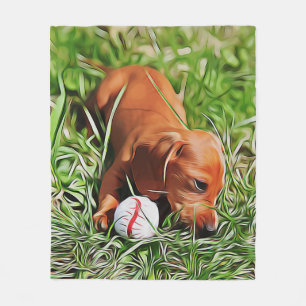 Dachshund-Welpe liegt im Gras mit Weihnachtsball Fleecedecke