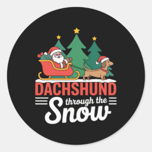 Dackel durch den schneefestlichen Weihnachtsfeiert Runder Aufkleber