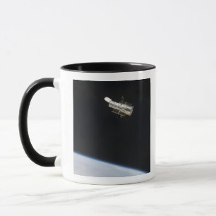 Das Hubble-Weltraumteleskop im Orbit über der Erde Tasse
