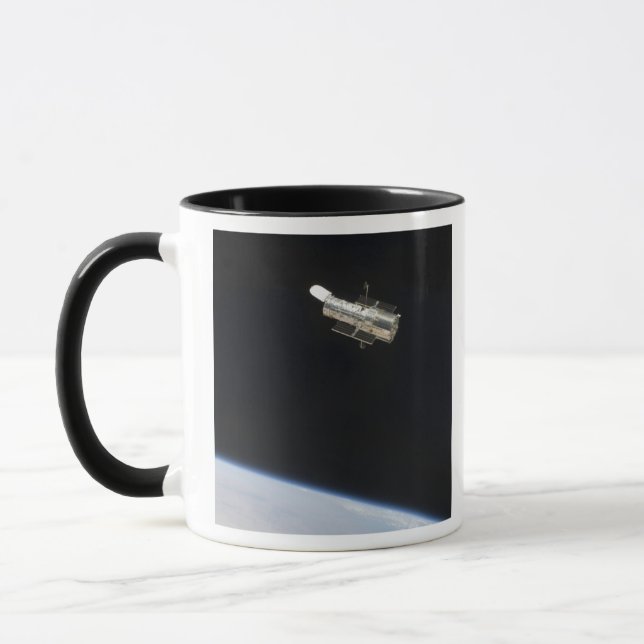 Das Hubble-Weltraumteleskop im Orbit über der Erde Tasse (Links)