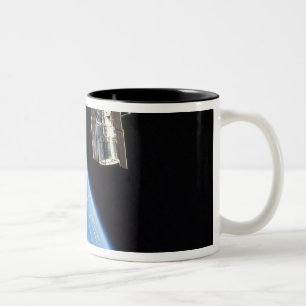 Das Hubble Weltraumteleskop mit einer blauen Erde Zweifarbige Tasse
