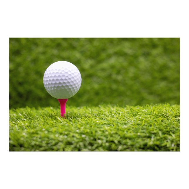 Der Golfball ist auf grünem Grasboden mit rosa Tee Fotodruck (Vorne)