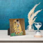 Der Kuss von Gustav Klimt Fotoplatte<br><div class="desc">Der Kuss von Gustav Klimt Der Kuss ist ein Ölgemälde mit Goldblatt, Silber und Platin vom österreichischen Symbolik-Maler Gustav Klimt. Es wurde irgendwann in den Jahren 1907 und 1908 gemalt, auf dem Höhepunkt dessen, was Gelehrte seine "Goldene Periode" nennen. Mit schimmernden Goldtönen, stilisierten Formen und sentimentaler Ikonographie verzaubert der Kiss...</div>