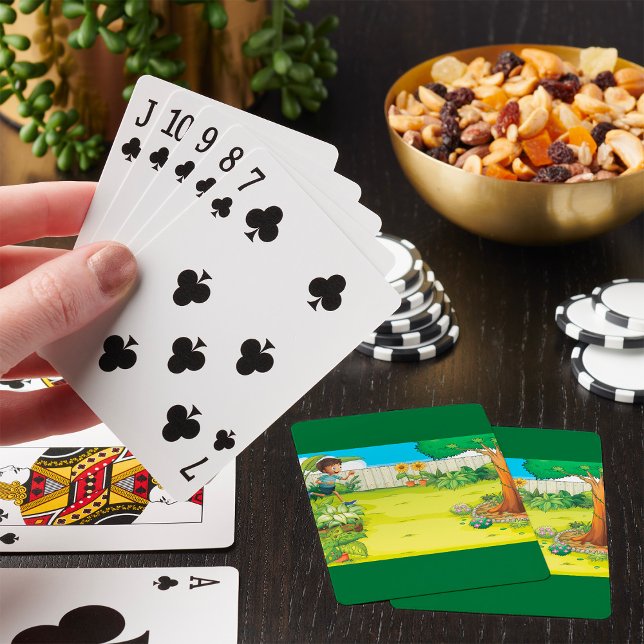 Der spielerische Junge, der in einem üppig grünen  Spielkarten (Von Creator hochgeladen)