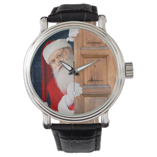 Der Weihnachtsmann versteckt sich hinter einer höl Armbanduhr