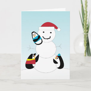 Des pingouins construisent une carte de Noël Snowm