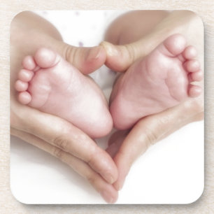 Dessous-de-verre Pieds de bébé dans des mains de mère