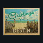 Destin Beach Vintage Travel Postkarte<br><div class="desc">Dieses Greetings From Destin Vintage Postcard Design verfügt über einen Sandstrand mit einem schönen türkisfarbenen Ozean Wasser und über dem Meer,  einem blauen Himmel mit billigen weißen Wolken. Im Vintage Reisen Stil.</div>