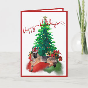 Deutscher Schäferhund liegt neben dem Weihnachtsba