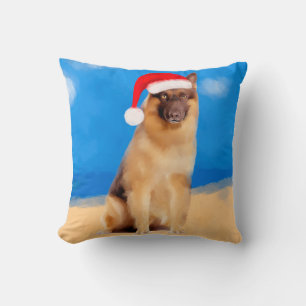 Deutscher Schäferhund sitzt auf der Weihnachtsmann Kissen