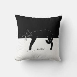 Die gerissene schwarze Katze hat ihre Pfoten gequä Kissen