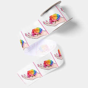 Die Hand einer Frau wiegt eine Regenbogenrose Satinband