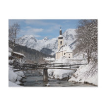 Die Kirche im Schnee mit den Alpen im Winter