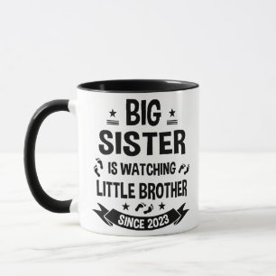 Die kleine Schwester kümmert sich um den großen Br Tasse