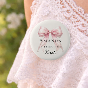 Die Knoten bindend rosa Schleife elfenbeinfarbene Button