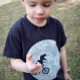 Dinosaurier auf einem Rad mit dem Mond Baby T-shirt (Von Creator hochgeladen)