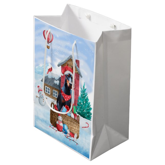 Doberman Hund im Schnee Weihnachtshundehaus Mittlere Geschenktüte (Vorderseite Schrägansicht)