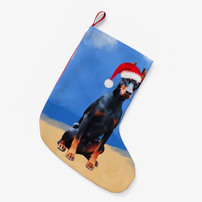 Doberman Hund sitzt auf Weihnachtshut am Strand Kleiner Weihnachtsstrumpf (Vorderansicht (hängend))