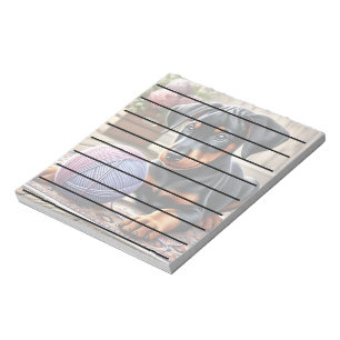 Doberman Puppy mit Garnball auf einem farbenfrohen Notizblock