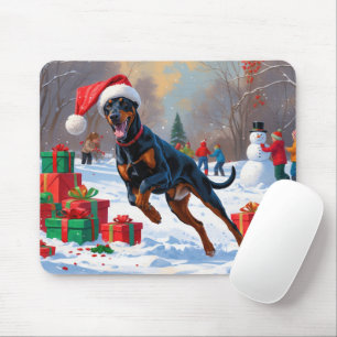 Dobermann läuft im Schnee mit Weihnachtsmütze Mousepad