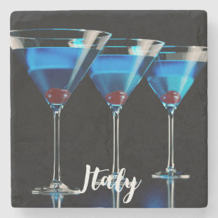 Drei blaue Cocktails mit Kirsche auf schwarz Steinuntersetzer