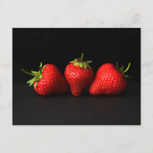 Drei Erdbeeren auf der schwarzen Straße Postkarte