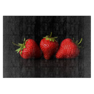 Drei Erdbeeren auf schwarzem Cbcnm Schneidebrett