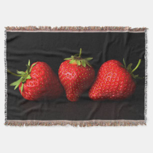 Drei Erdbeeren mit schwarzem Knochenkraut Decke