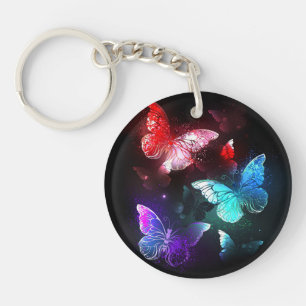 Drei glühende Schmetterlinge im Hintergrund Schlüsselanhänger