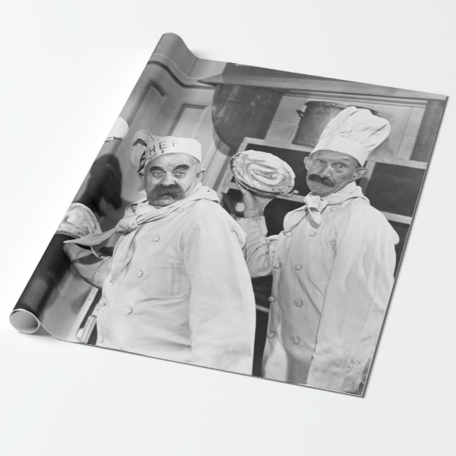 Drei Köche, die Kuchen für einen Kämpfen in der Kü Geschenkpapier (Ungerollt)
