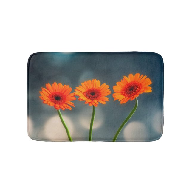 Drei Orange Gerberas in einer Row-Badematte Badematte (Vorderseite)