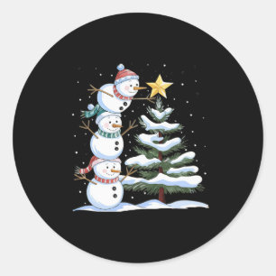 Drei Schneemänner richten einen Weihnachtsbaum ein Runder Aufkleber