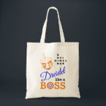 Dreidel wie ein Boss Hanukkah Tragetasche<br><div class="desc">Stilvolle DREIDEL WIE EINE BOSS Hanukkah Tote Bag, die mit orangefarbenem DREIDEL und blau, orange und schwarz Typografie entworfen wurde. In der rechten oberen Ecke können Sie die Namen der vier dreidimensionalen Seiten in einem Wortpuzzle-Format lesen (HEI kann bei Bedarf in HEY oder HAY geändert werden). In der O von...</div>
