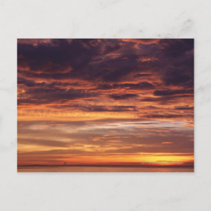 Dunkle Wolken in orangefarbenem Himmel Postkarte