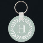 Dusty Sage Green Botanical Wreath Monogram Schlüsselanhänger<br><div class="desc">Mit diesem personalisierten Minzgrün und Weiß mit Monogramm Schlüsselanhänger im Stil ergänzen. Das Design besticht durch moderne Blätter mit Lorbeerkranzen und eine stilvolle Typografie. Monogramm in der Mitte ist einfach zu anpassen. Eine elegante und nützliche Brautjungfrau,  Trauzeuge und Brautparty-Sake-Idee und ergänzt schicke Hochzeitsgrün.</div>