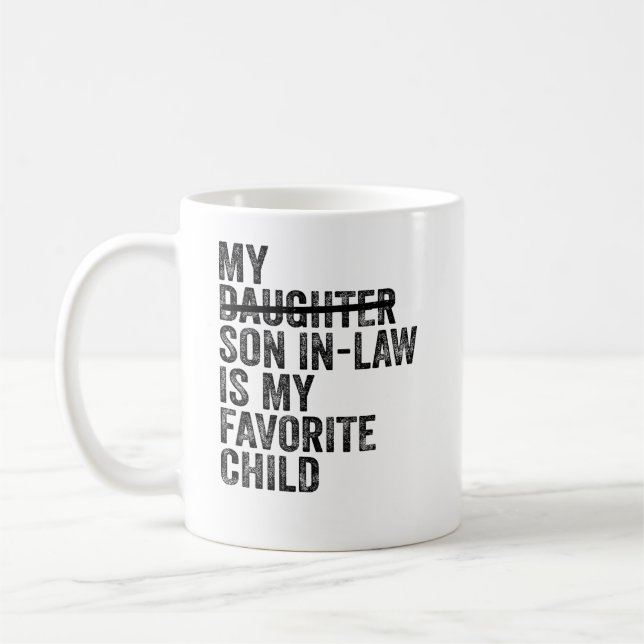 Ehemännischer Sohn einer Familie, der sich in eine Kaffeetasse (Links)