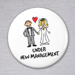Ehepaar - unter neuer Leitung Magnet<br><div class="desc">Ein niedlicher Cartoon eines frisch verheirateten Paares mit dem Titel "unter neuer Leitung". Ist es die Braut oder der Bräutigam, die die Hose in der Ehe trägt? Ideal für ein Hochzeitsgeschenk, oder um Flitterwochen zu tragen.</div>