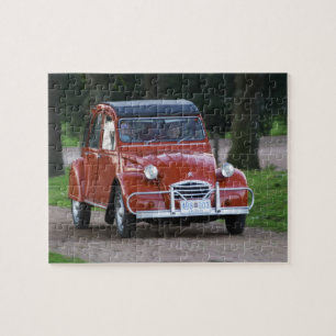 Ein alter roter Citroen 2CV Wagen mit einer lächel
