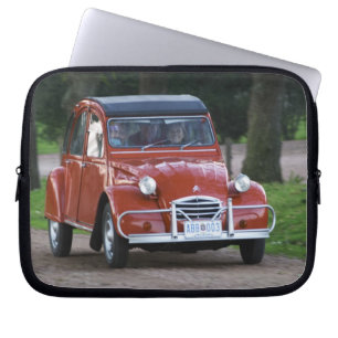 Ein alter roter Citroen 2CV Wagen mit einer lächel Laptopschutzhülle