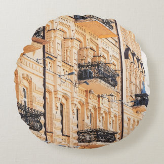 Ein altes gelbes Haus mit schmiedeeisernen Balkone Rundes Kissen