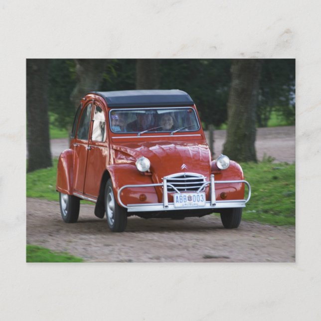 Ein altes, rotes Citroen 2CV Auto mit einer lächel Postkarte (Vorderseite)