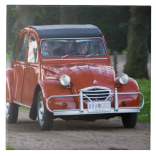 Ein altes rotes Citroen 2CV Auto mit einer lächeln Fliese