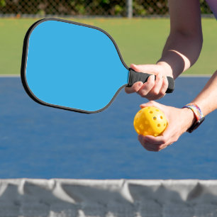 ein blauer Hintergrund mit einer schwarz-weißen Ka Pickleball Schläger